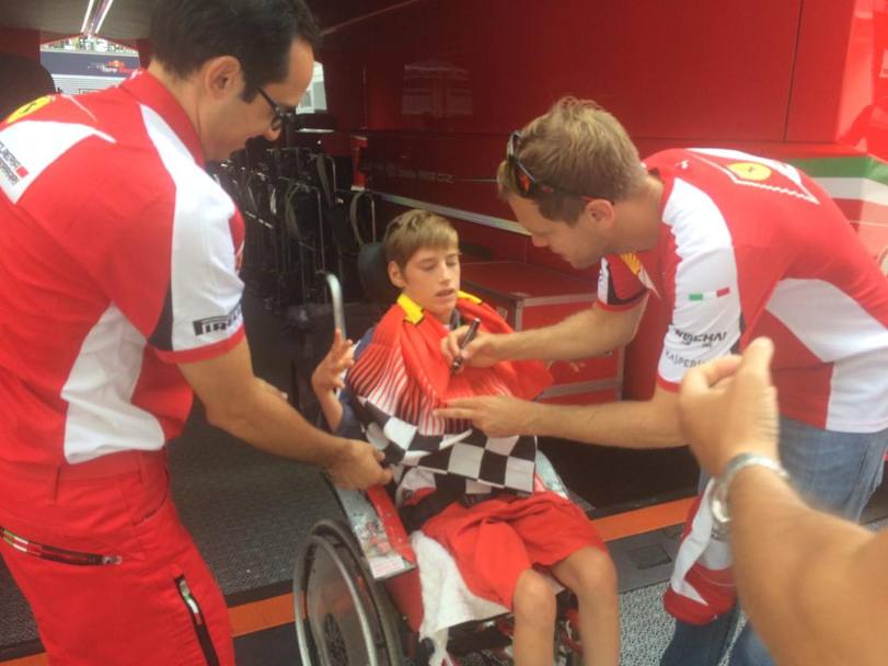 Vettel firma un autografo a un bambino disabile